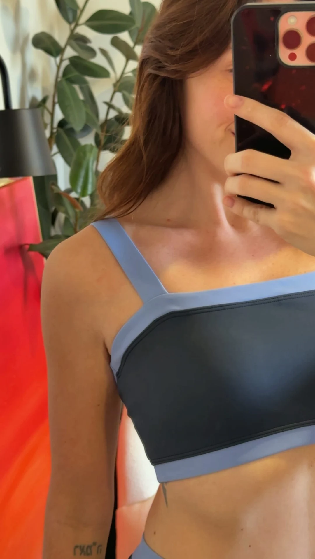 Rafaela com roupa esportiva azul em uma selfie no espelho
